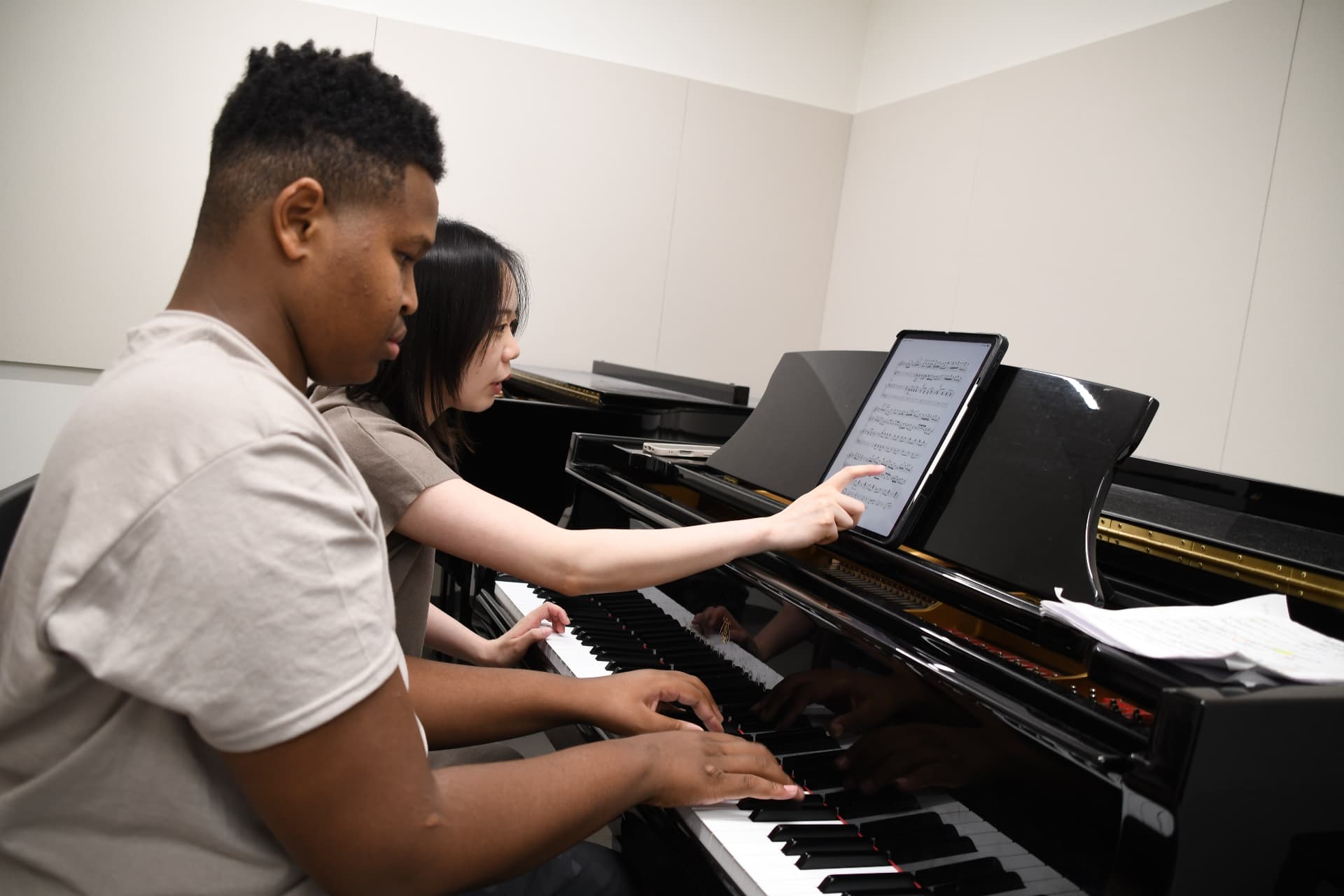 Yi-Hui Chen teaching a piano student in a bright studio