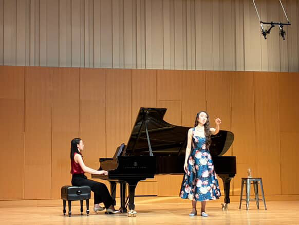 Yi-Hui Chen at the piano accompanying a soprano on a concert stage