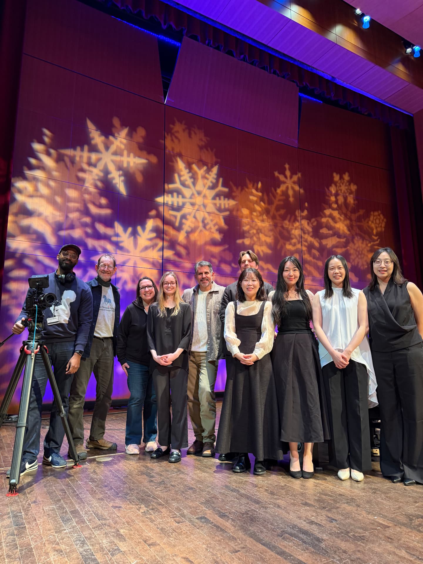 Yi-Hui Chen on stage with fellow performers under snowflake projections